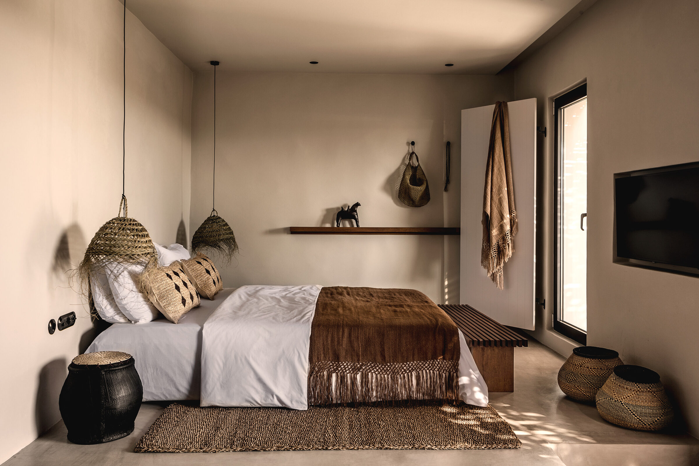Junior Suite room accommodations at luxury five-star hotel OKU Kos feature a separate bedroom area with king size bed and nature-inspired interiors